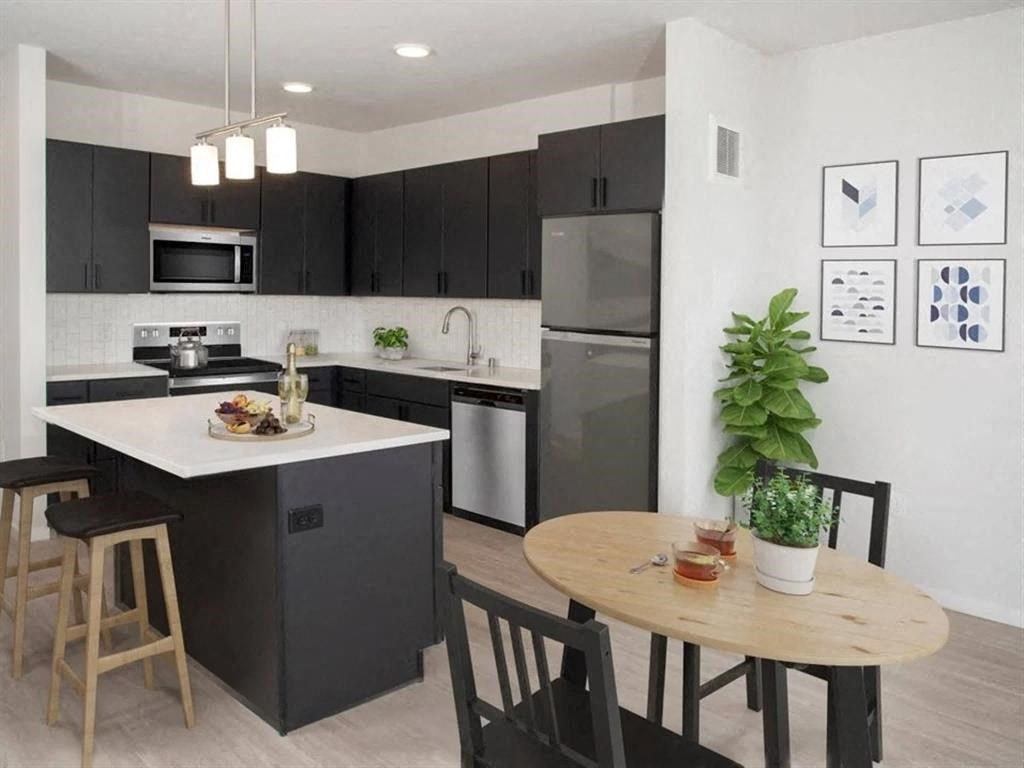 A modern kitchen with a dining table and chairs.