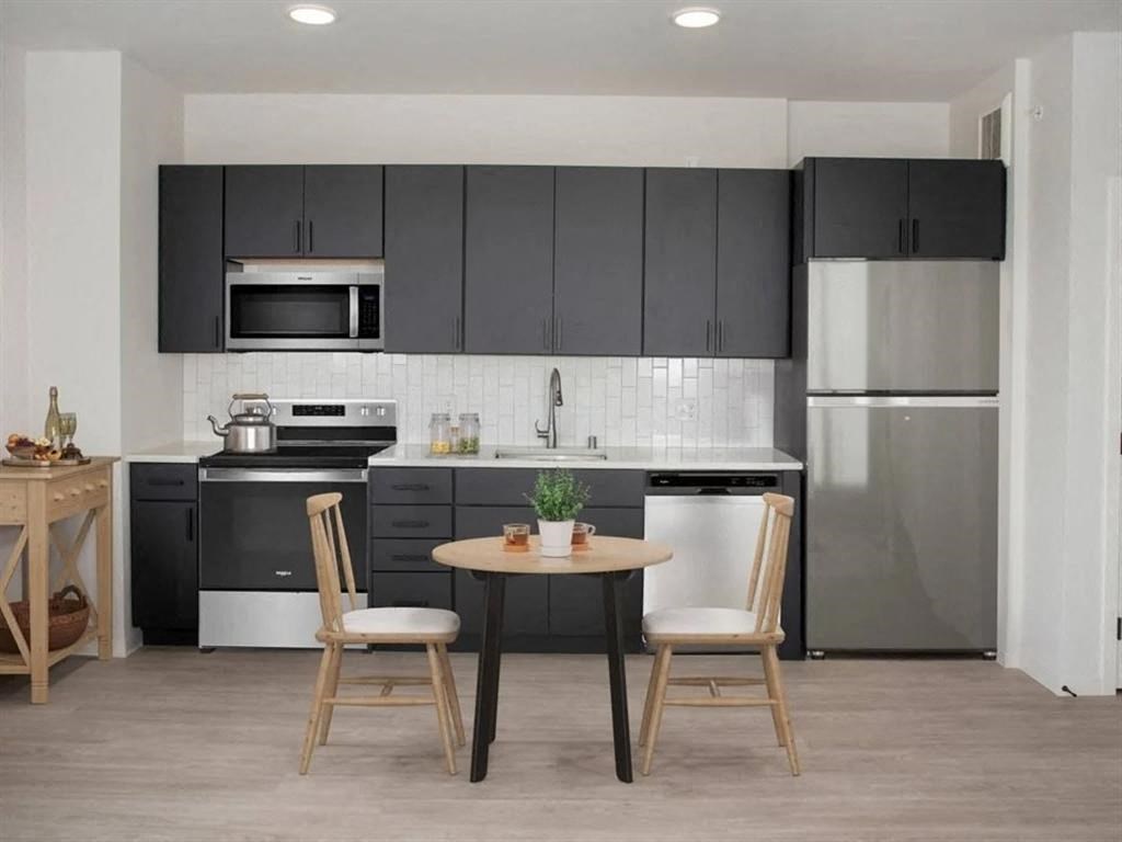A modern kitchen with a table and chairs.