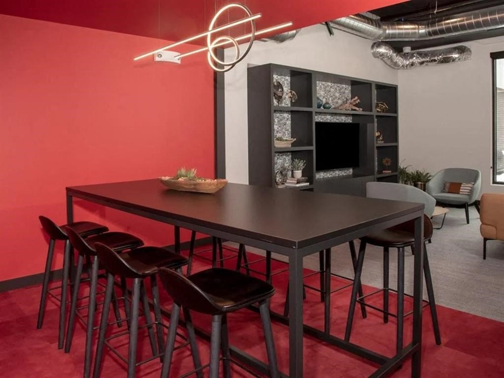 A modern dining area with a dark table and chairs.