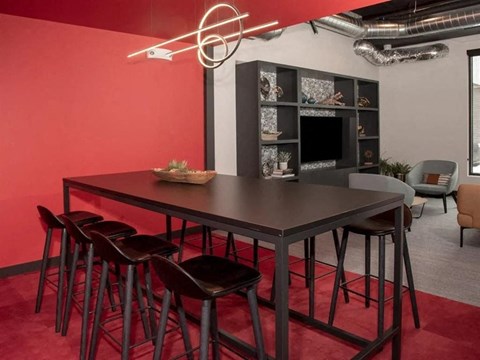 A modern dining area with a dark table and chairs at The Redwell Apartments, Minneapolis, 55401