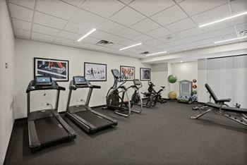 A gym with treadmills, exercise bikes, and other equipment.