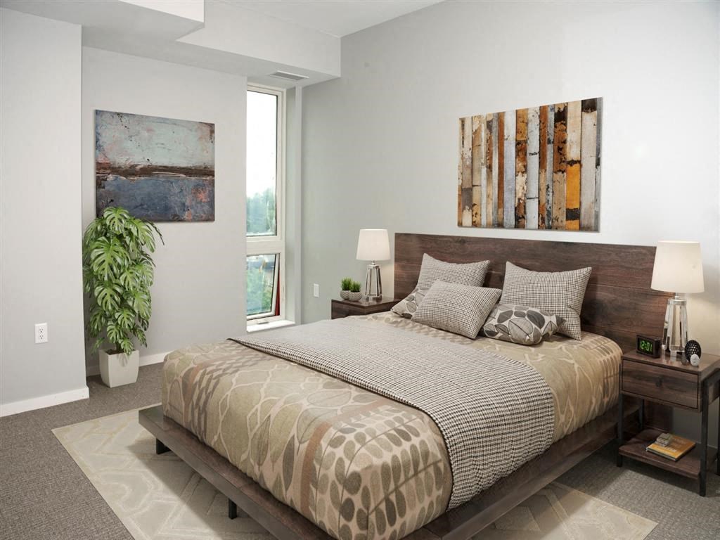 A bedroom with a large bed and a painting on the wall.