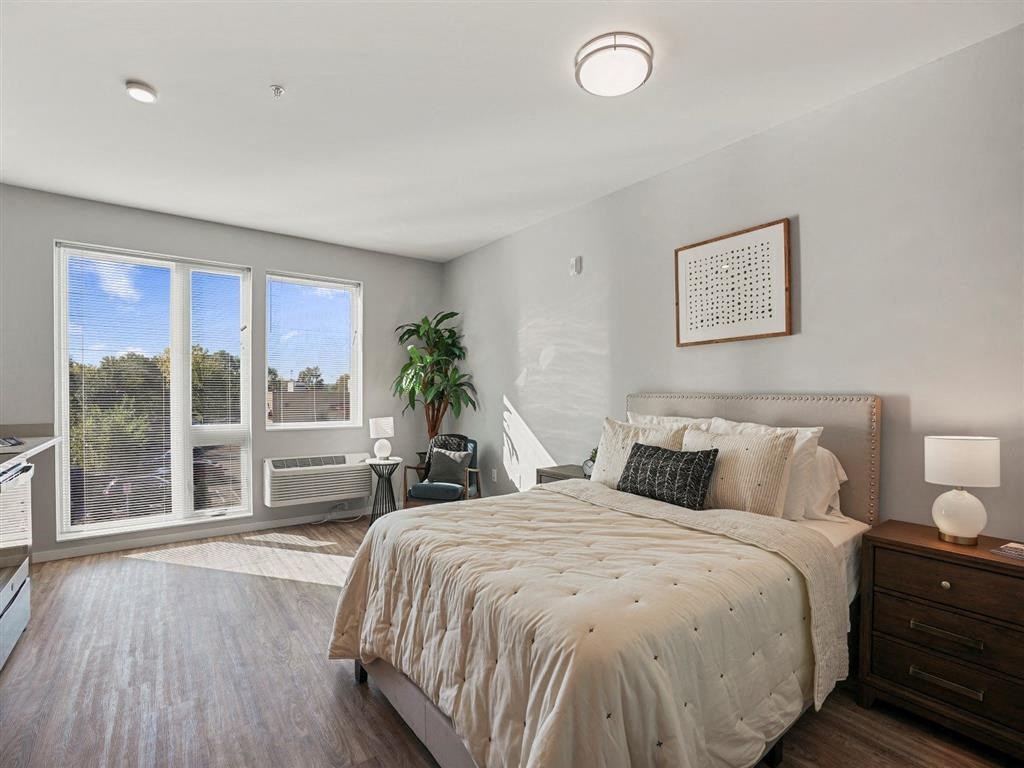 A bedroom with a large bed and a view of the outdoors through the sliding glass doors.