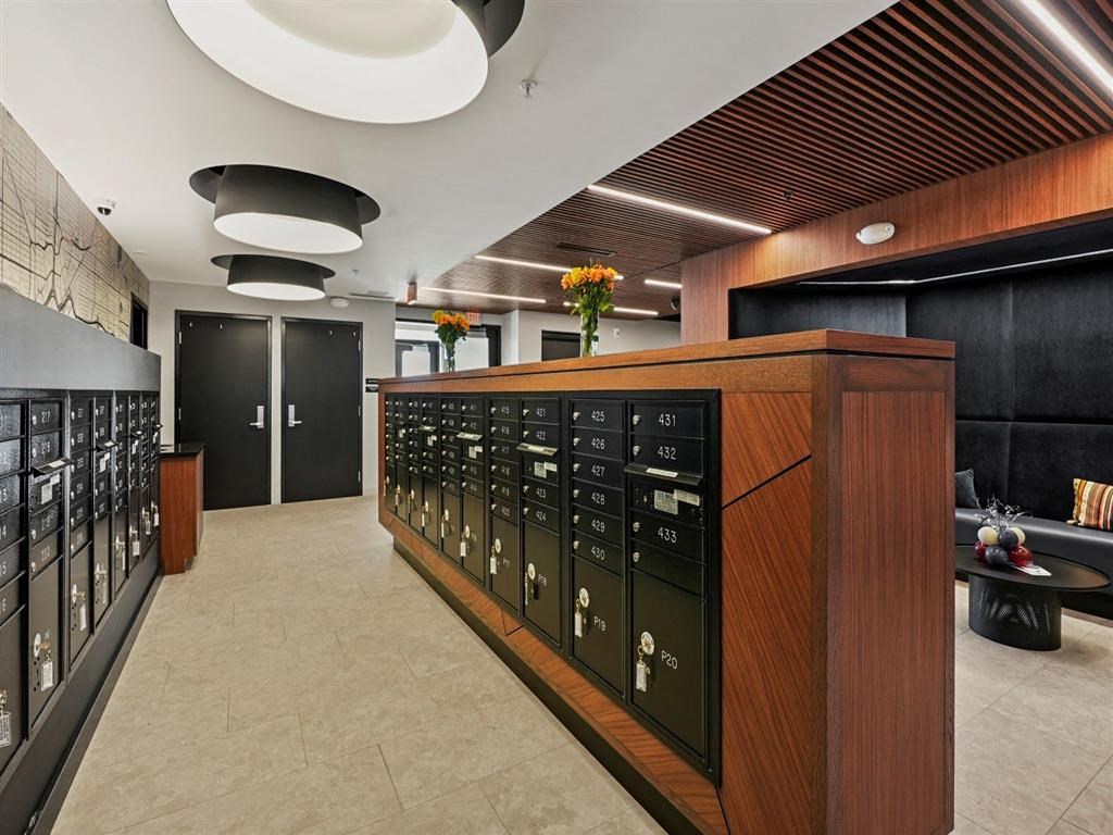 A modern office lobby with a reception desk and a wall of lockers.