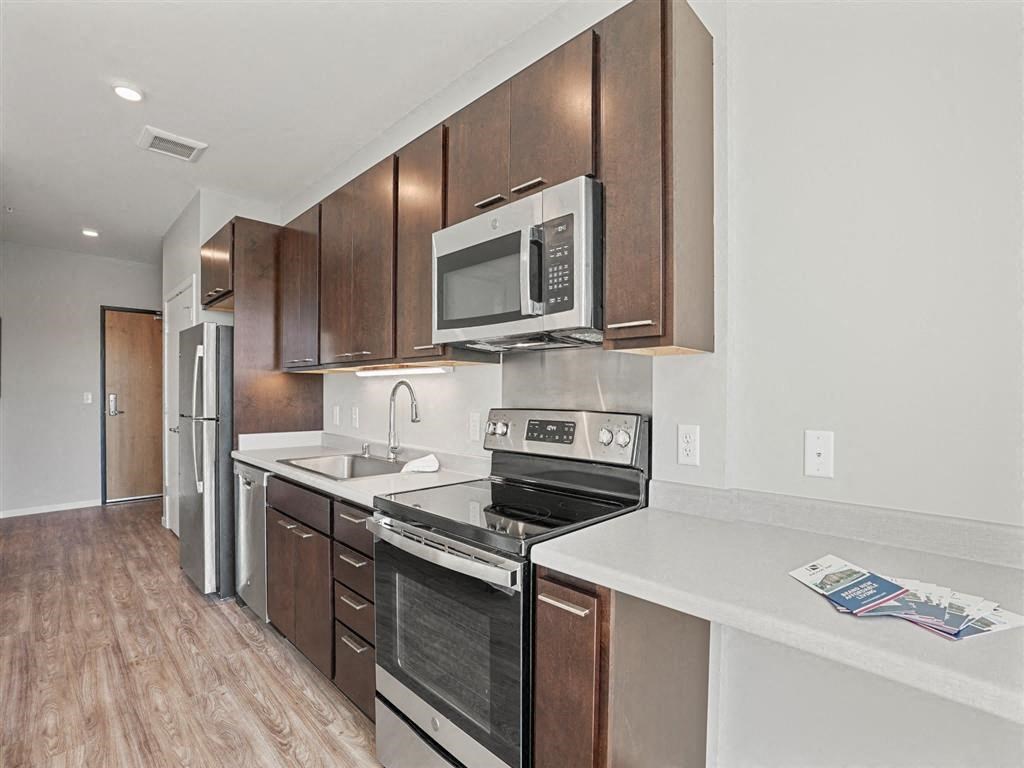 A kitchen with brown cabinets and stainless steel appliances.