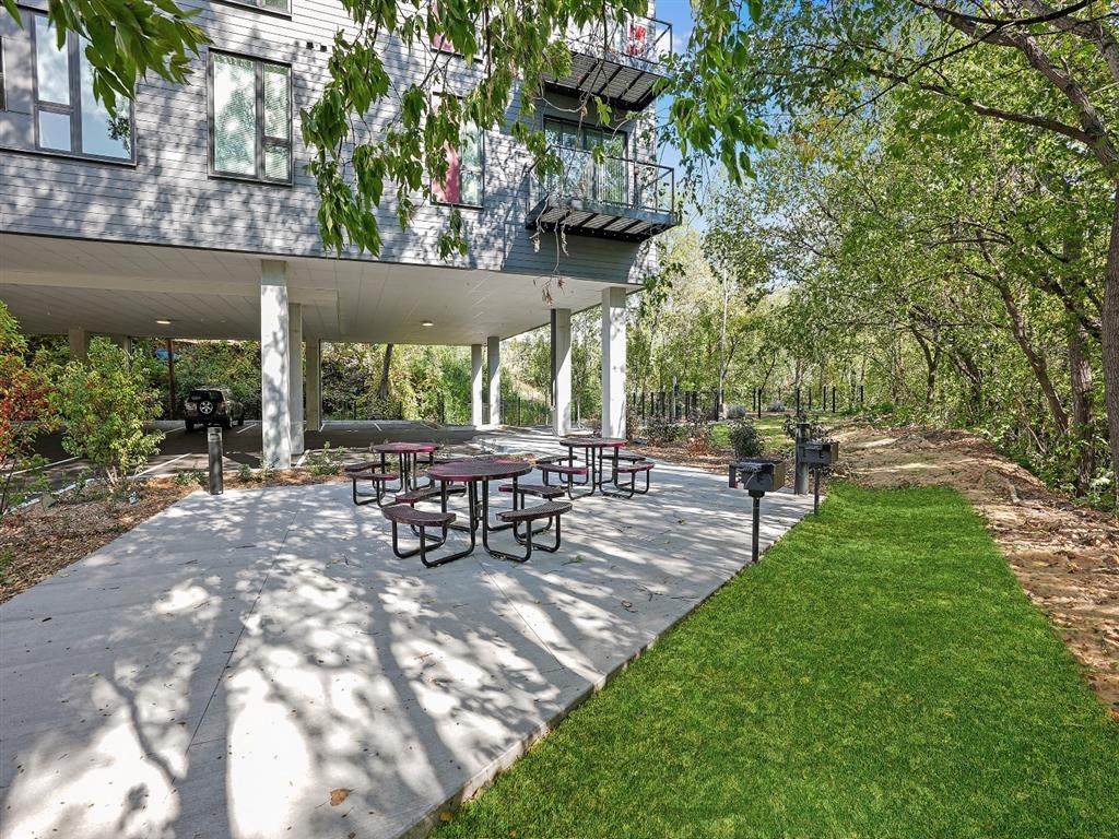 A patio with a table and chairs is surrounded by trees.