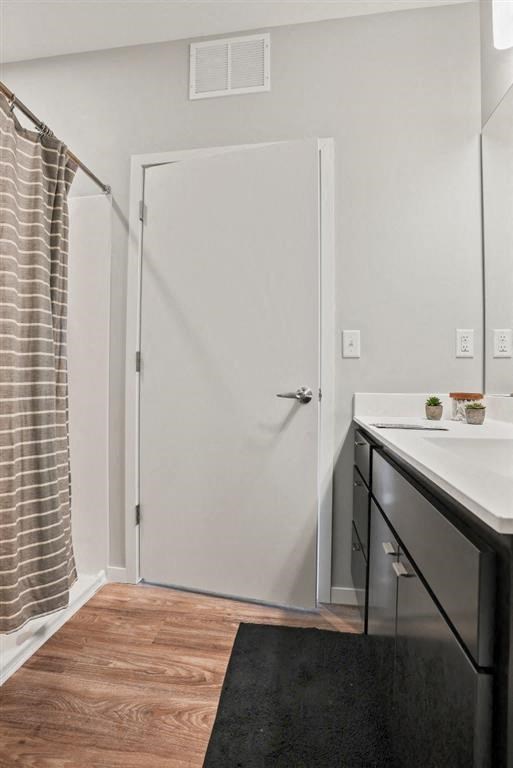 A white door is in a room with a black rug and wooden flooring.