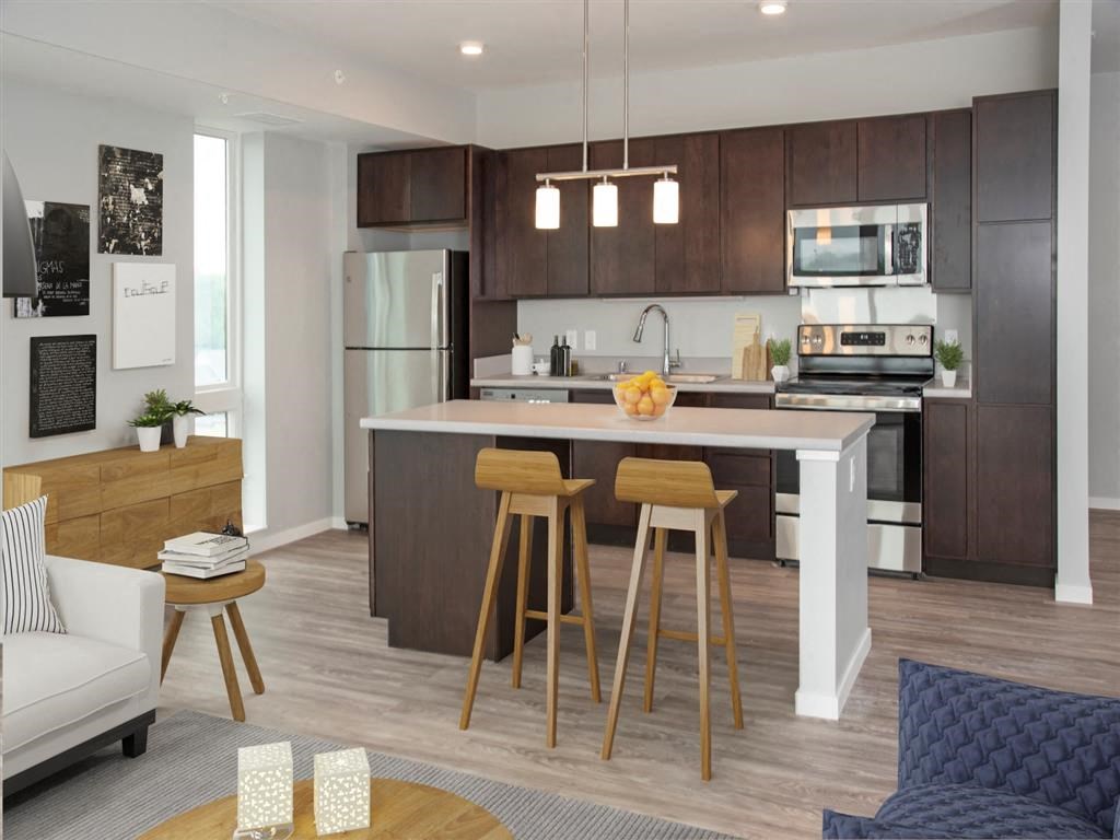 A modern kitchen with a white island and wooden stools.