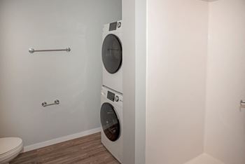 A white washing machine in a small bathroom.