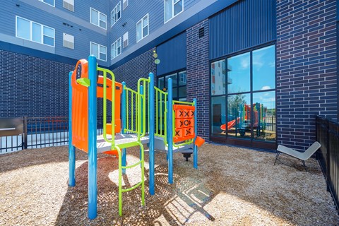 A playground with a slide, swings, and a climbing frame at Soul Apartments, Minnesota 55107