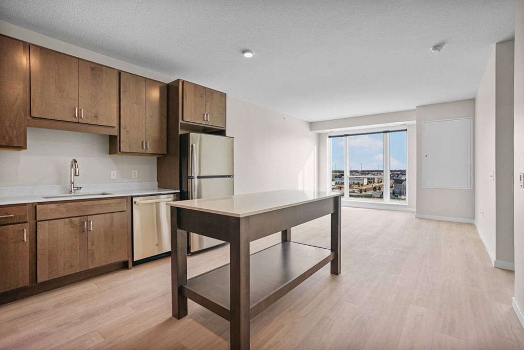 A kitchen with wooden cabinets and a refrigerator.at Croft at Rosecott, Rosemount, MN 55068