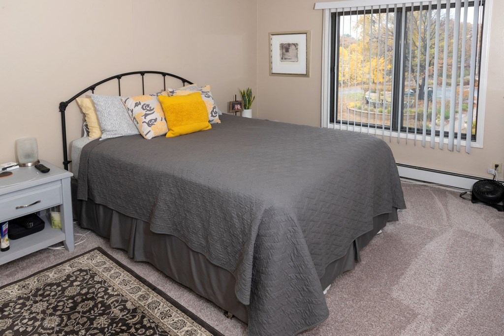 a bedroom with a bed and a large window