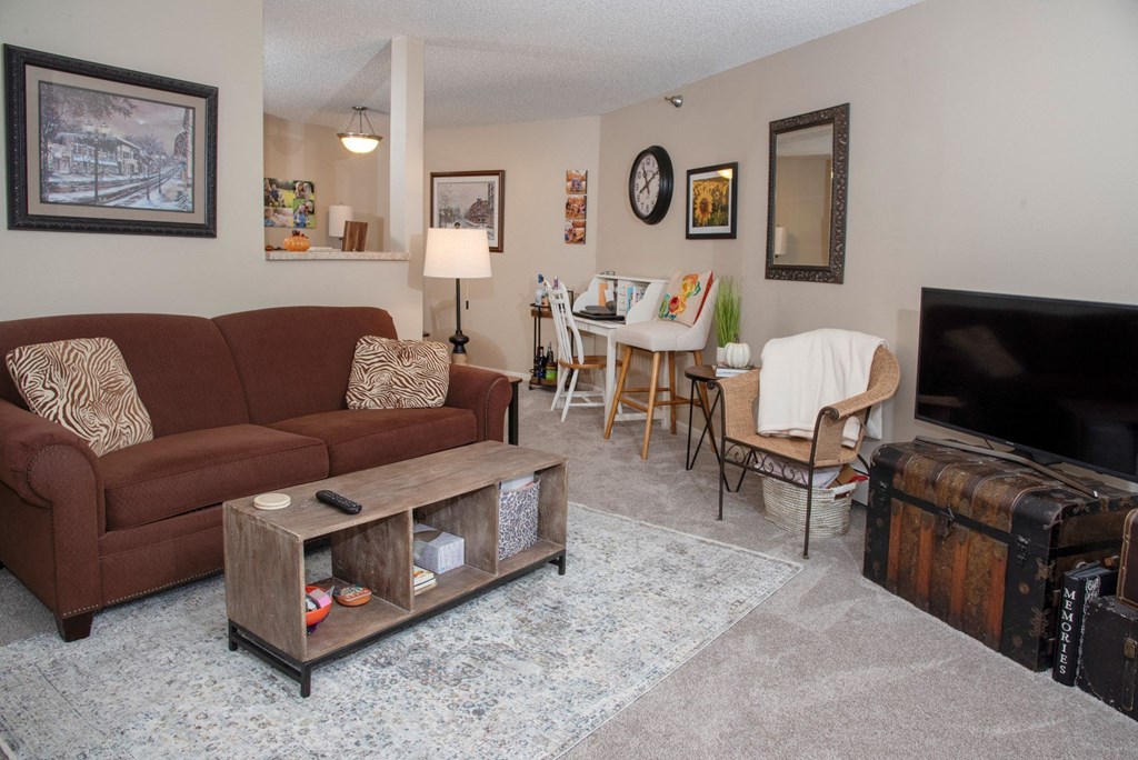 a living room with a couch and a tv and a dining room table