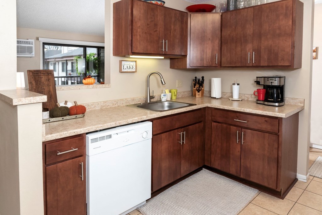 a kitchen with wooden cabinets and a sink and a dishwasher