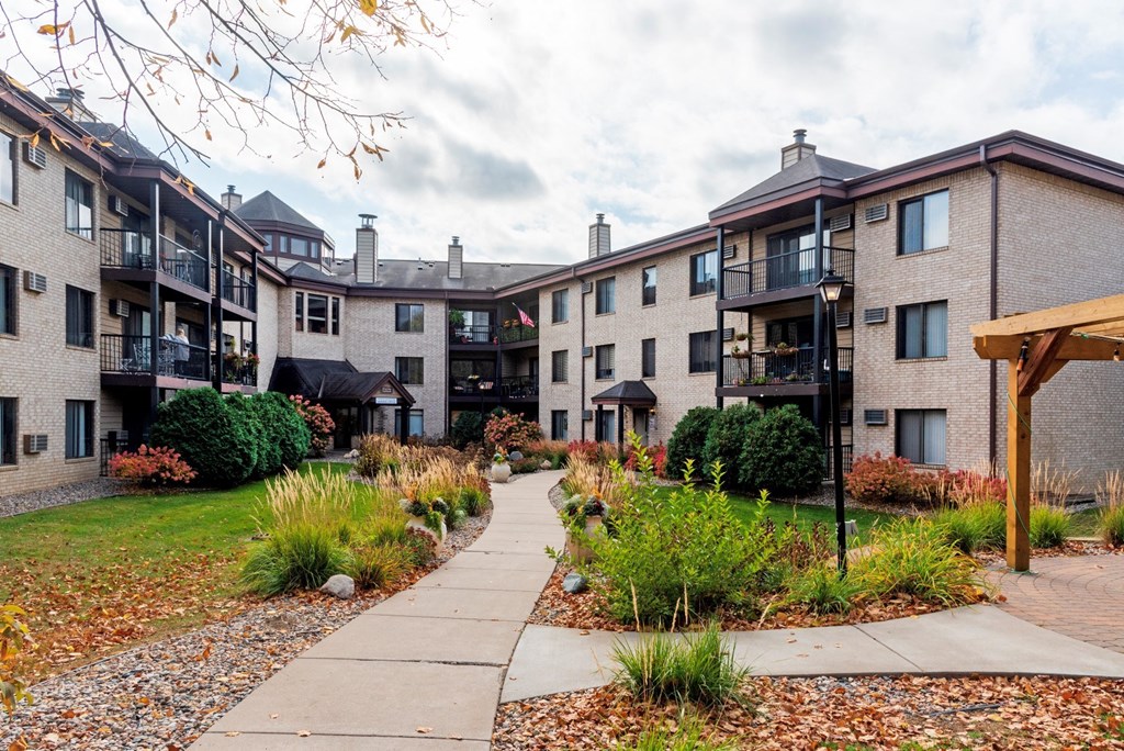 an exterior view of an apartment building with a sidewalk