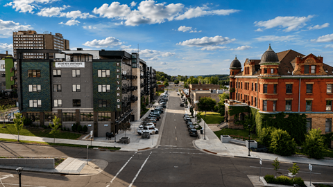 A street view of a city with cars parked on the side of the road.