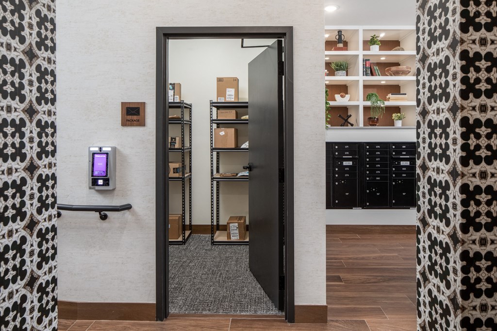 a corridor with a black door and a white wall with shelves in the background