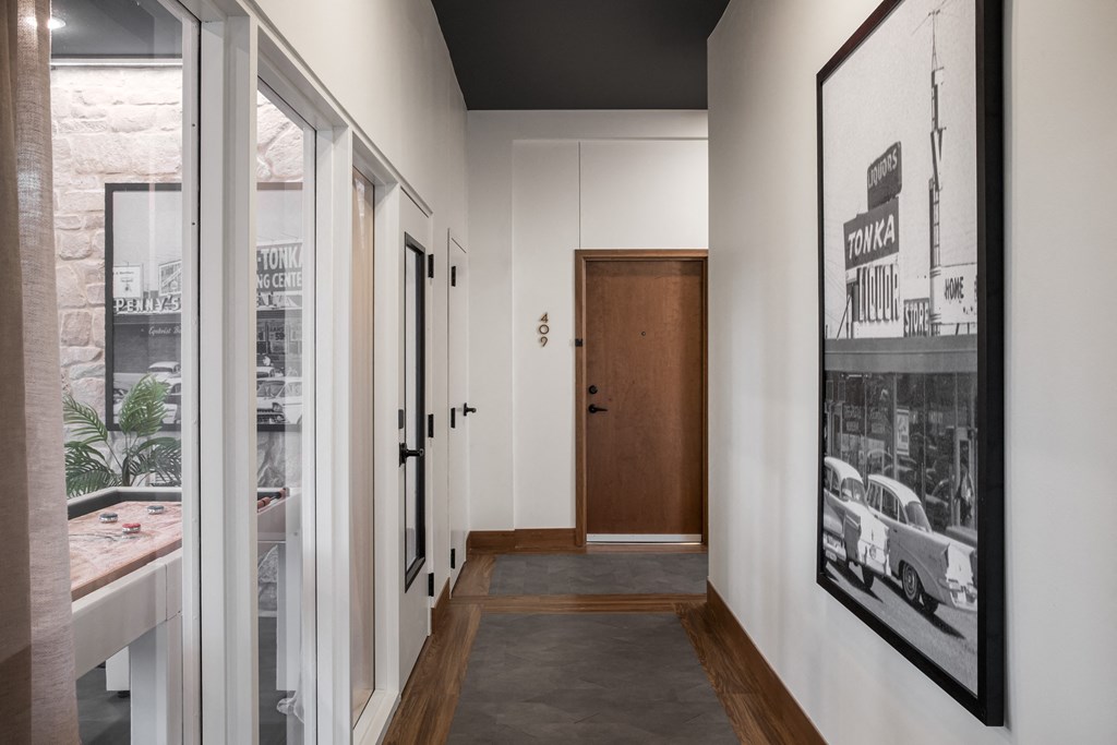 a view down the hallway of a house with white walls and a black ceiling