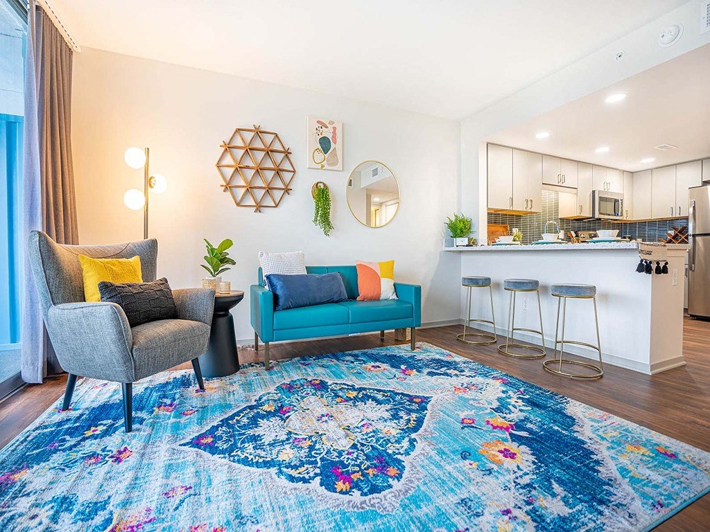 a living room and kitchen with a blue rug