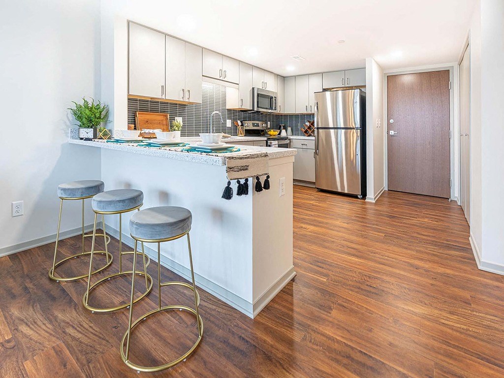 a kitchen with a bar with three stools
