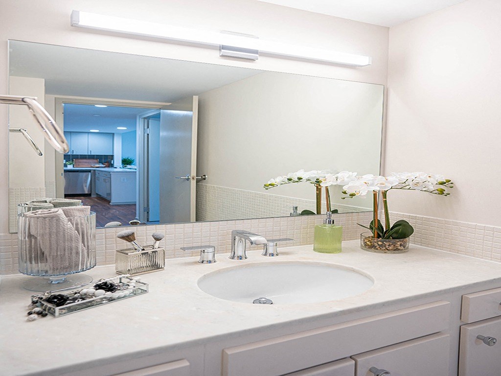 a white bathroom with a sink and a large mirror