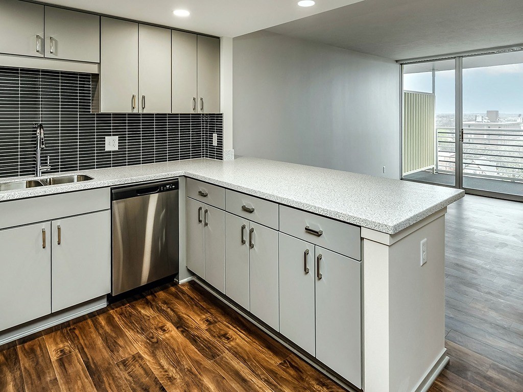 an empty kitchen with white cabinets and a stainless steel dishwasher