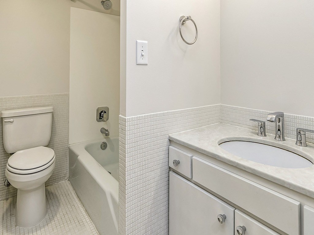 a bathroom with a toilet and a sink and a bath tub