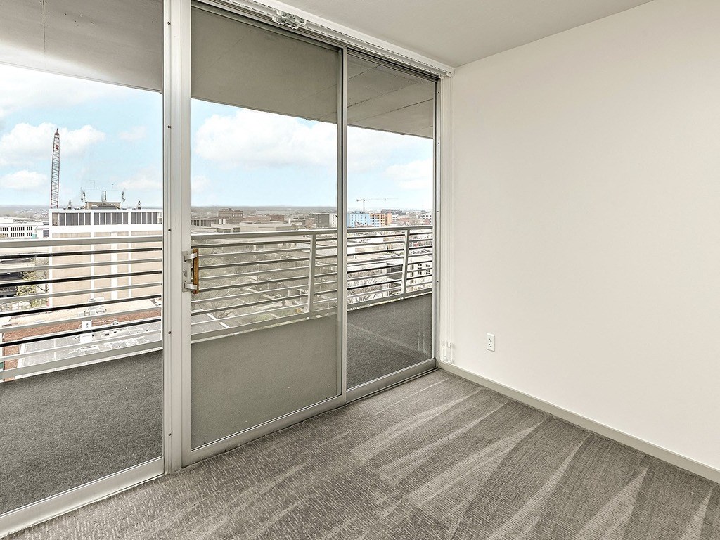 an open balcony with sliding glass doors and a view of the city