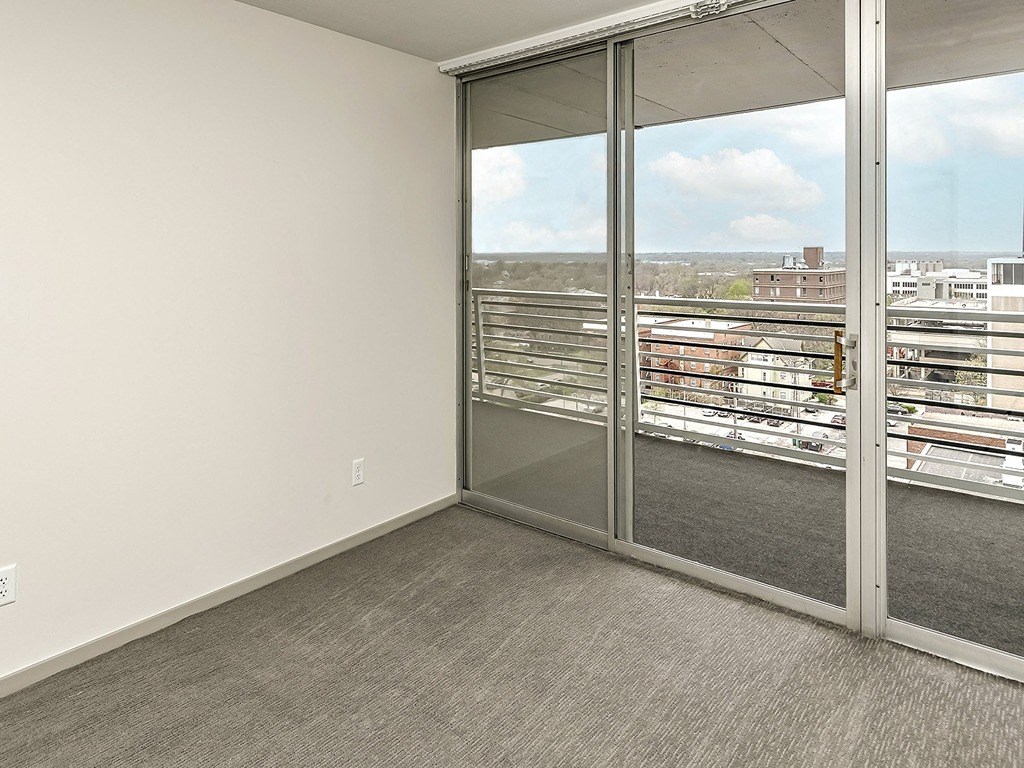 an open living room with glass doors and a view of the city