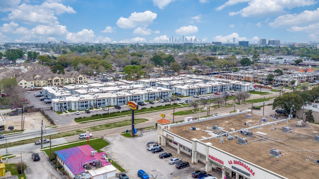 an aerial view of a parking lot in a city with buildings and a city skyline