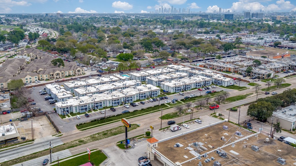 an aerial view of an empty parking lot in front of apartment buildings
