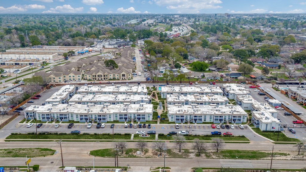an aerial view of a parking lot filled with white buildings