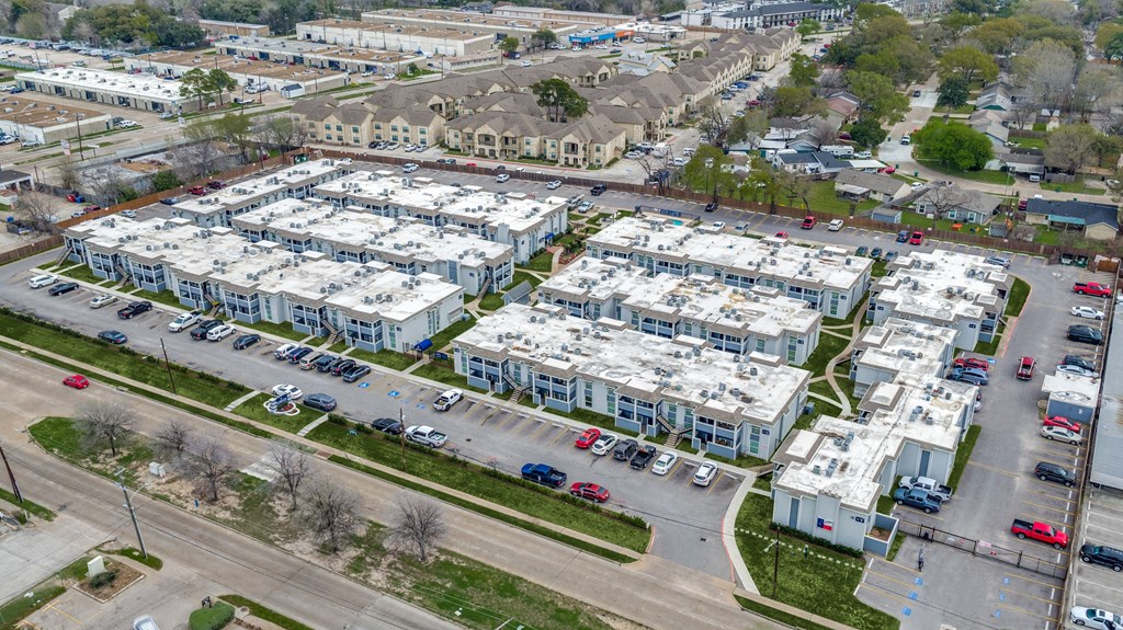 an aerial view of apartment buildings and cars in a parking lot