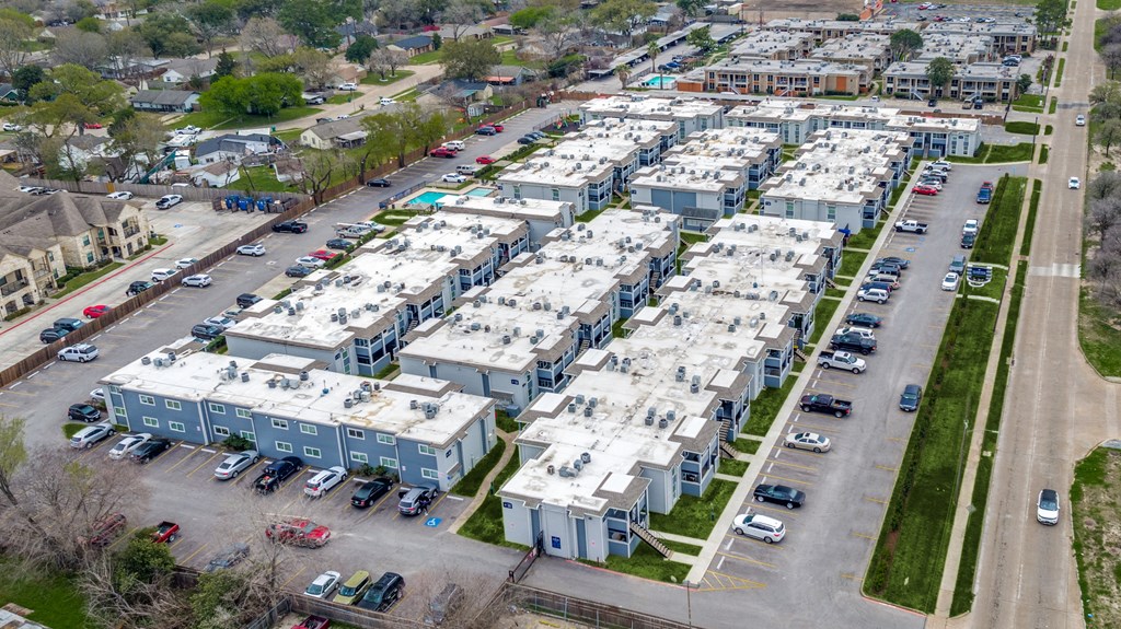 an aerial view of rows of apartment buildings in a parking lot
