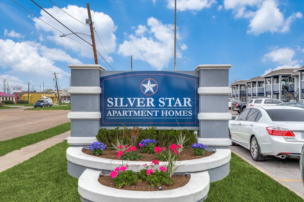 the sign for silver star apartment homes in front of a parking lot with cars