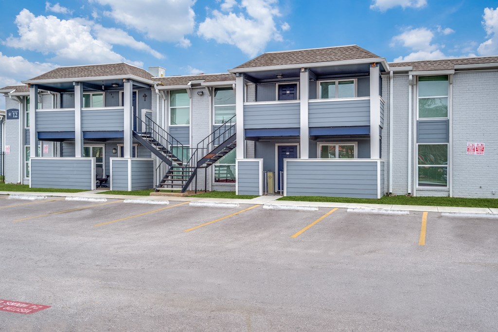 an empty parking lot in front of an apartment building
