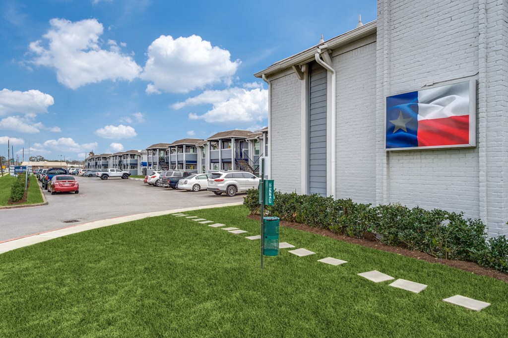 a building with a sign on the side of it and a parking lot with cars