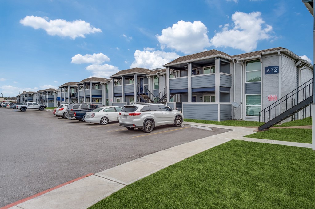 a row of houses with cars parked in front of them