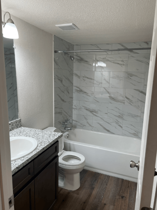 a bathroom with a toilet and a tub and a sink