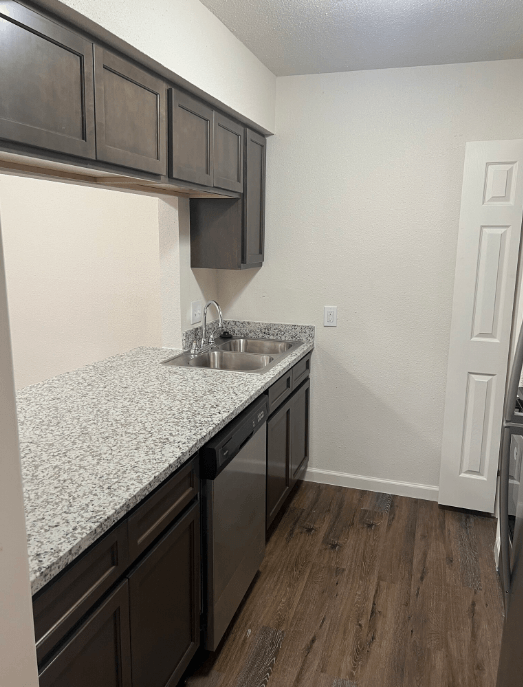 a kitchen with granite countertops and a stainless steel sink