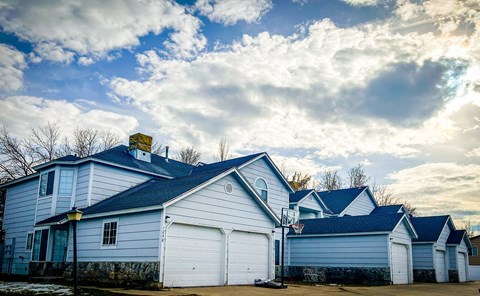 a group of white houses with a cloudy sky in the background
