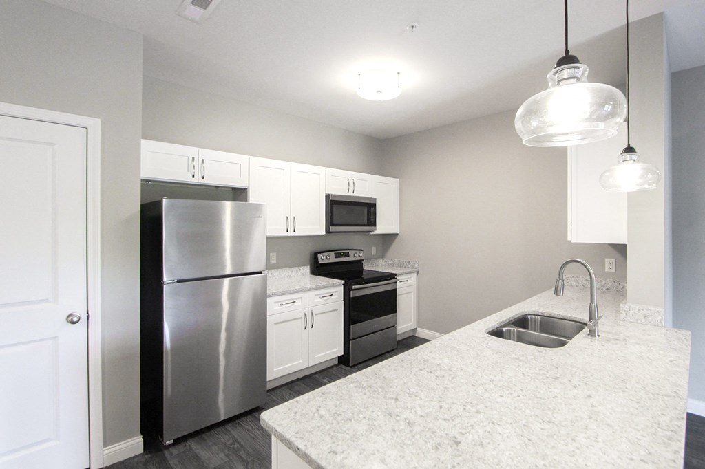 a kitchen with white cabinets and stainless steel appliances