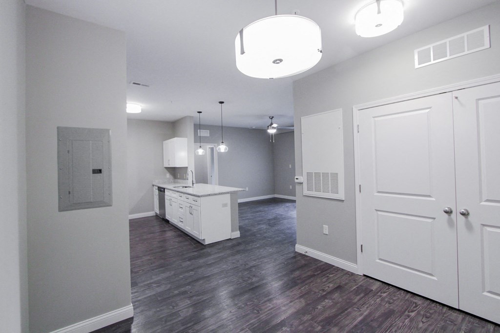 the living room and kitchen of a new home with white cabinets and a white island