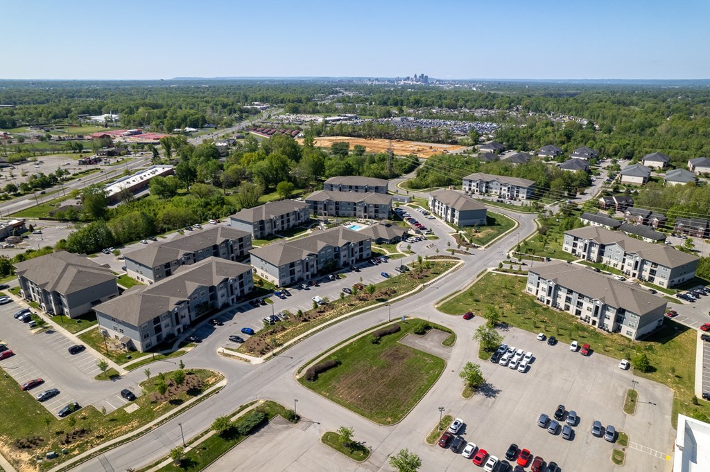 an aerial view of a city with houses and cars parked on the street