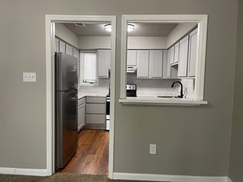 A kitchen with a refrigerator and a countertop.