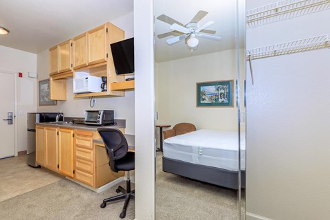 A bedroom with a bed, desk, and chair.