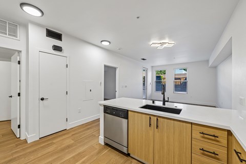 A modern kitchen with wooden floors and white walls.