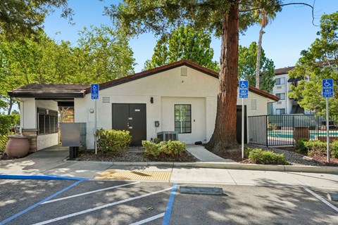 A small building with a parking lot in front of it.