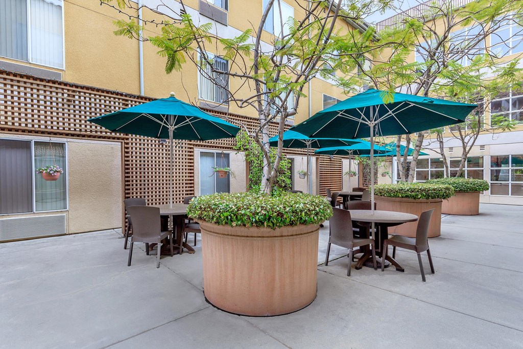 A Patio With Tables And Umbrellas at Atrium Garden Apartment Homes, LLC, San Jose, California