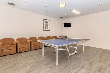 A Ping Pong Table In The Middle Of a Room at Atrium Garden Apartment Homes, LLC, California